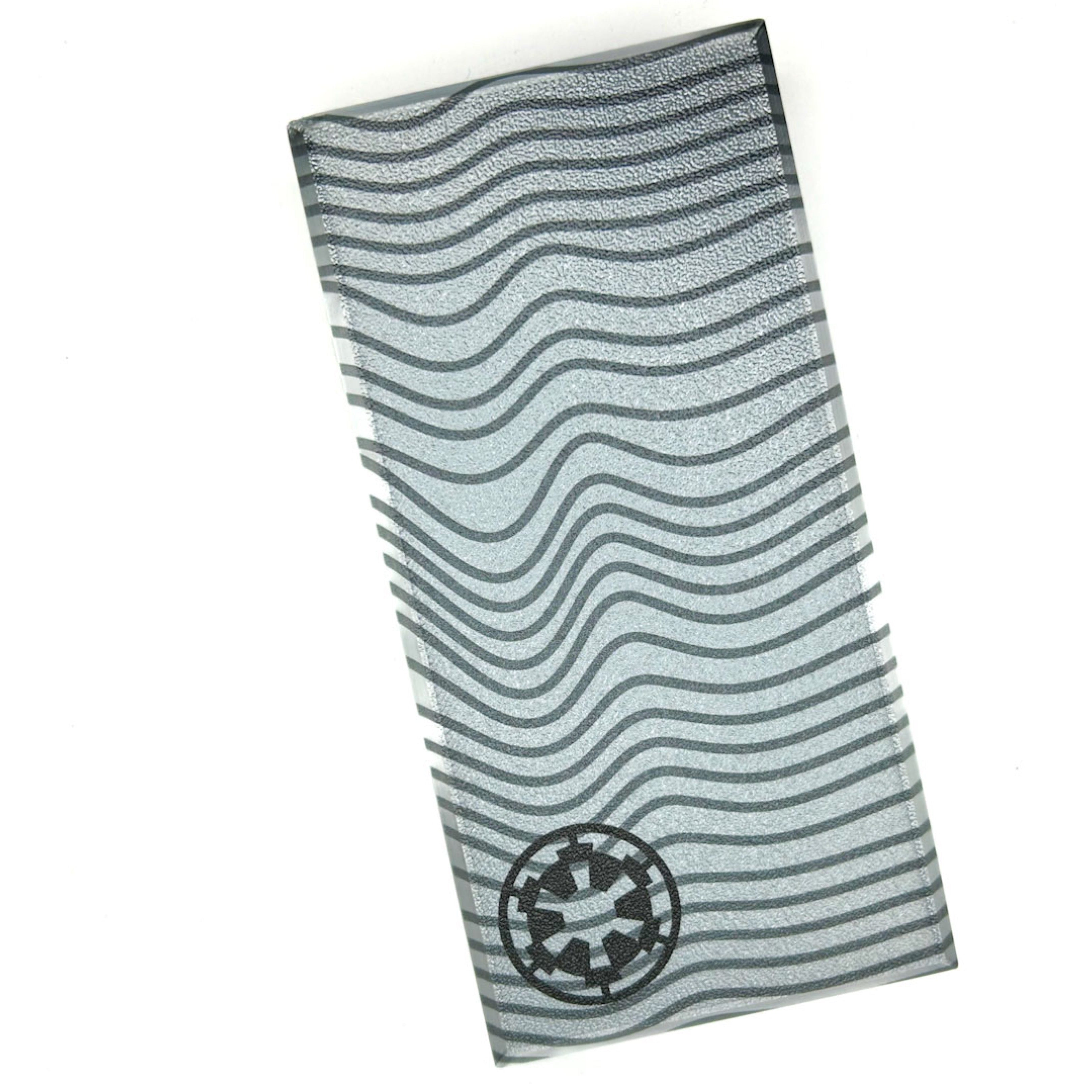 Silver life-size 1x2 tile with wavy black lines and an emblem, 3D printed by B3 Customs as a Life-Size Beskar Tile / Cosplay piece.