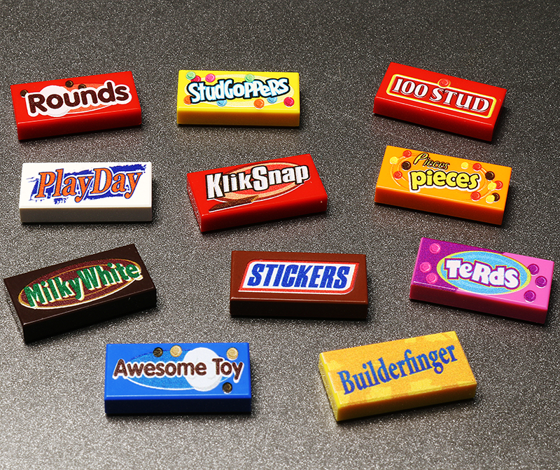Colorful miniature candy boxes recreated as LEGO bricks featuring playful spoof candy names, showcasing the Candy Pack (Series 2) made using LEGO parts with detailed custom printed tiles.