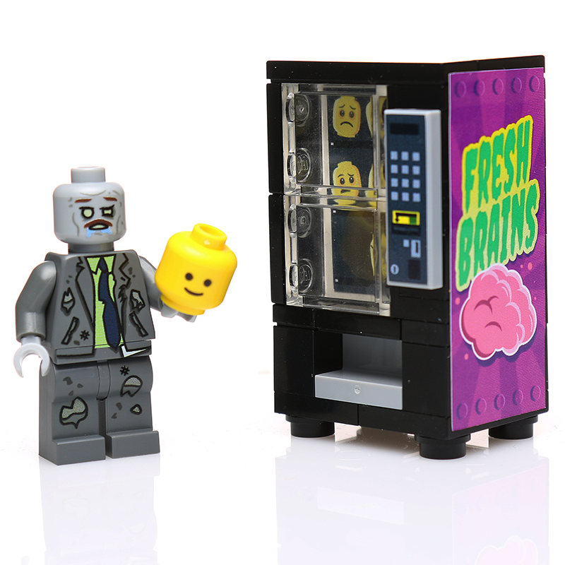 A custom LEGO Fresh Brains Zombie Vending Machine w/ Zombie Minifig by B3 Customs, featuring a detailed zombie minifigure holding a yellow LEGO head next to a purple vending machine branded with "Fresh Brains.