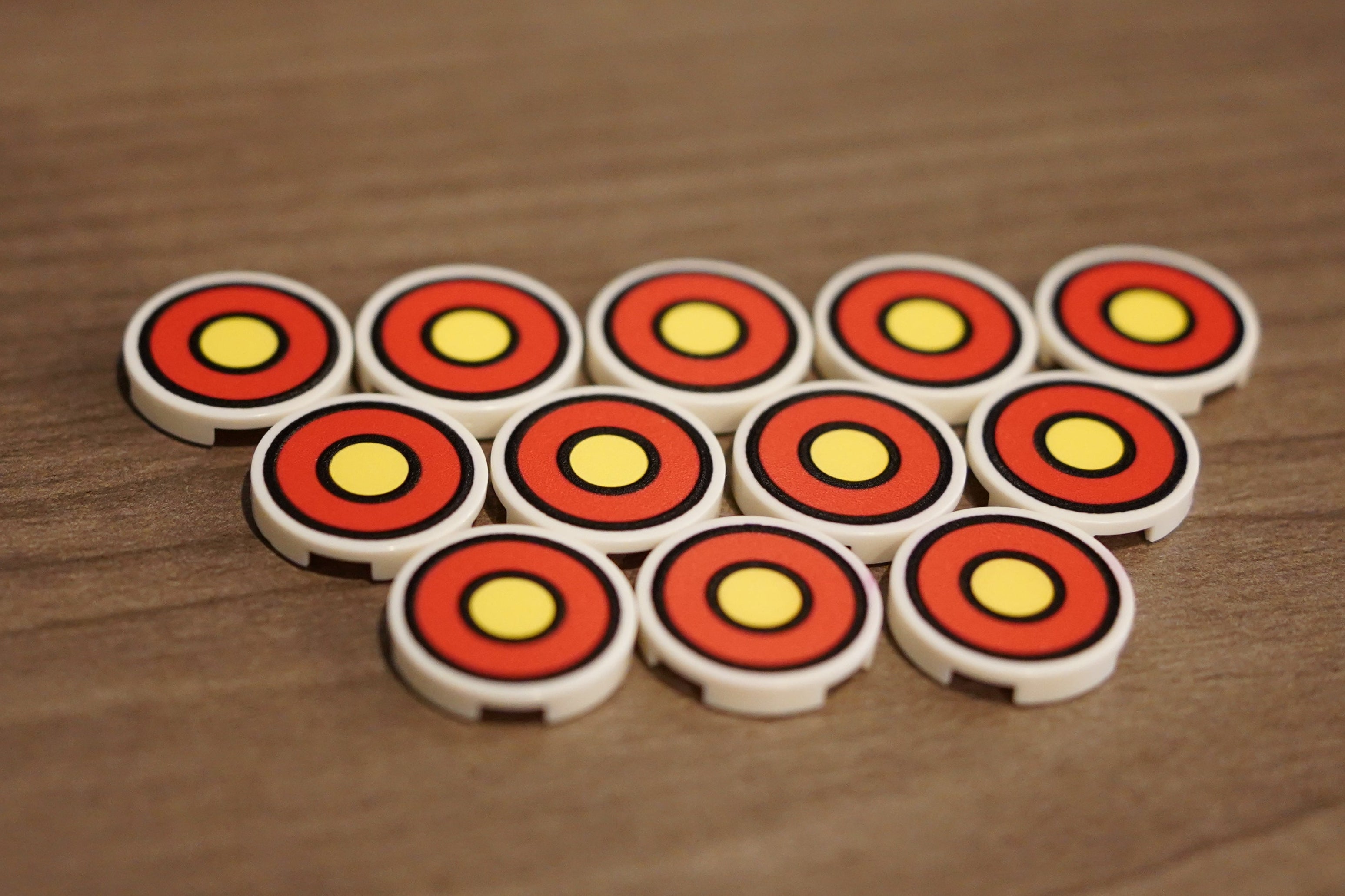 Set of round game pieces with red and yellow patterns on a wooden surface