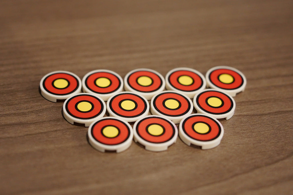 Set of round game pieces with red and yellow patterns on a wooden surface