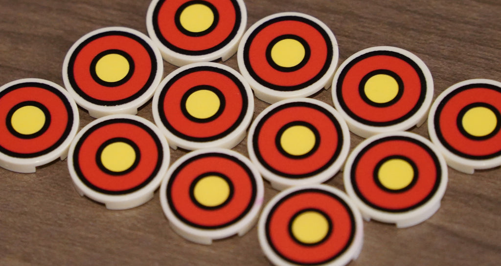 Circular objects with red and yellow concentric circles on a wooden surface