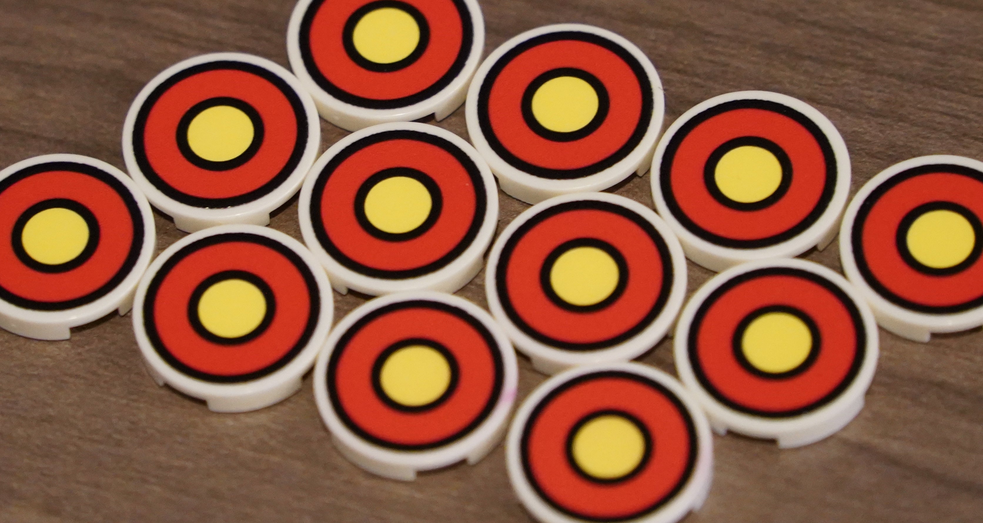 Circular objects with red and yellow concentric circles on a wooden surface