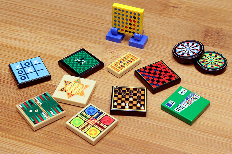 A collection of miniature classic board games and card games made from colorful LEGO parts, showcasing intricate designs and vibrant pieces from the Classic Board Games Pack made using LEGO parts - B3 Customs.