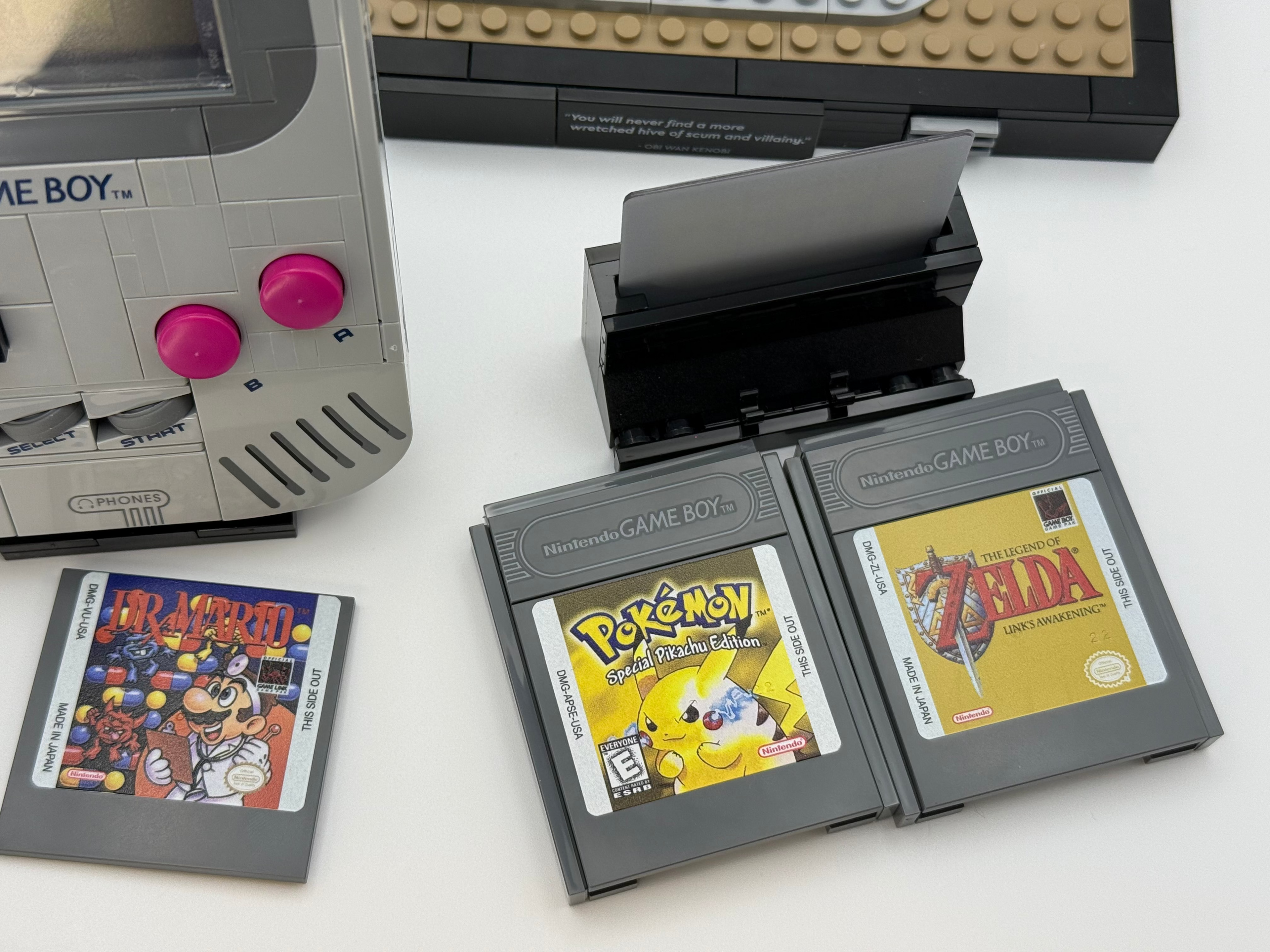 Close-up of classic Nintendo Game Boy cartridges featuring Mario, Pokémon, and Zelda labels with the Printed Tile Upgrade Kit for GB Set Game Cartridge enhancing the original game tiles.