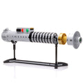 Luke Skywalker ROTJ Lightsaber w/ Stand - Custom MOC made with LEGO bricks by B3 Customs, featuring detailed gray and gold elements displayed on a sleek black stand.