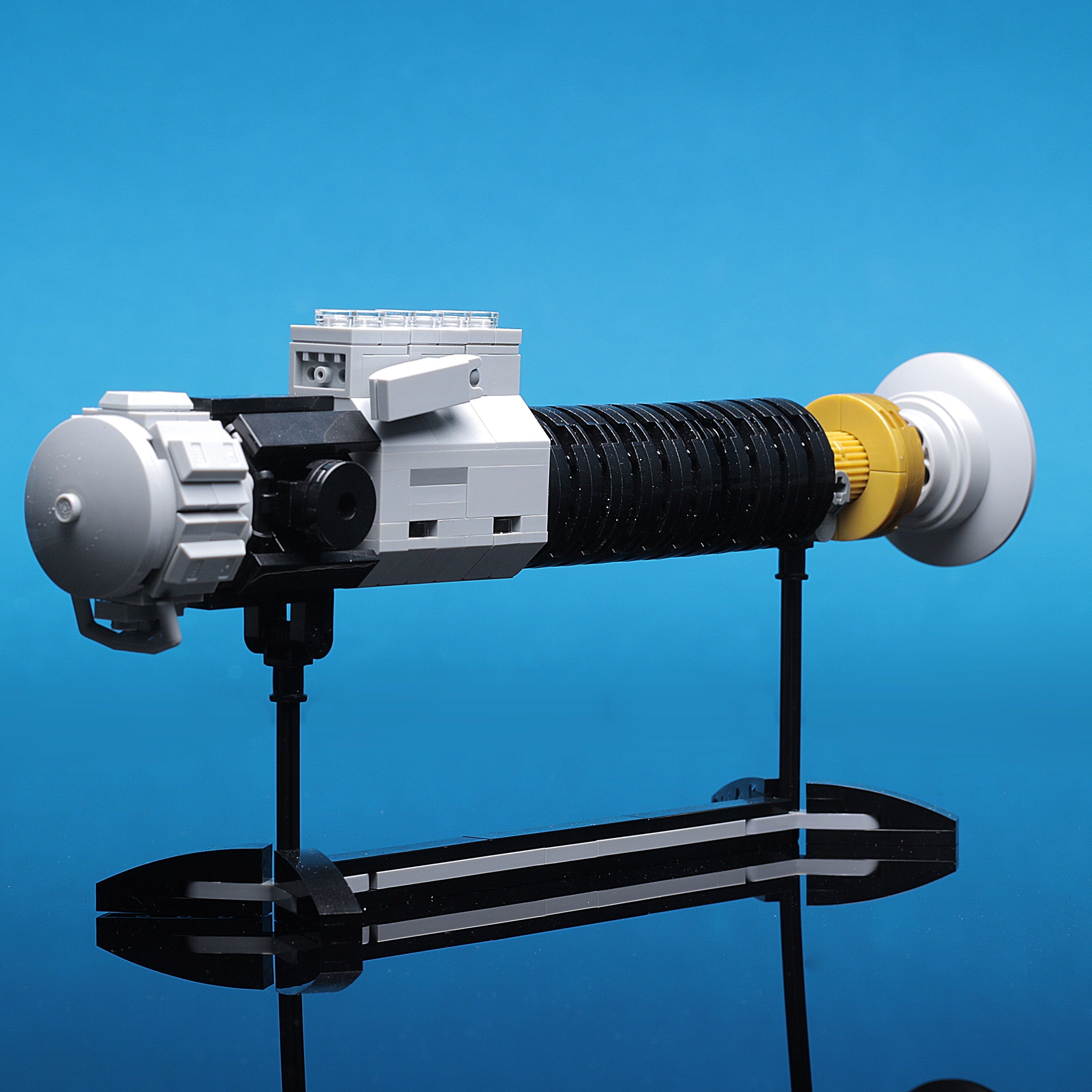 Obi-Wan Lightsaber w/ Stand made with LEGO parts featuring detailed craftsmanship and a sleek black and white design with yellow accents, perfect for display.