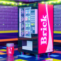 A detailed LEGO vending machine model in red and black with custom printed soda cans and a matching cup, designed by B3 Customs as the Brick - B3 Customs Soda Vending Machine made using LEGO parts.