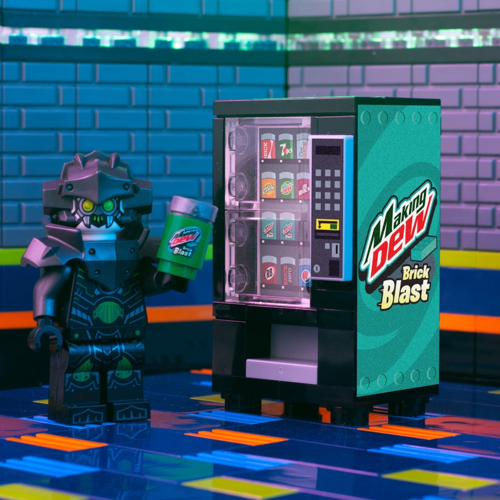 A custom LEGO vending machine with "Making Dew (Brick Blast)" branding next to a detailed minifigure holding a branded soda can, crafted by B3 Customs.