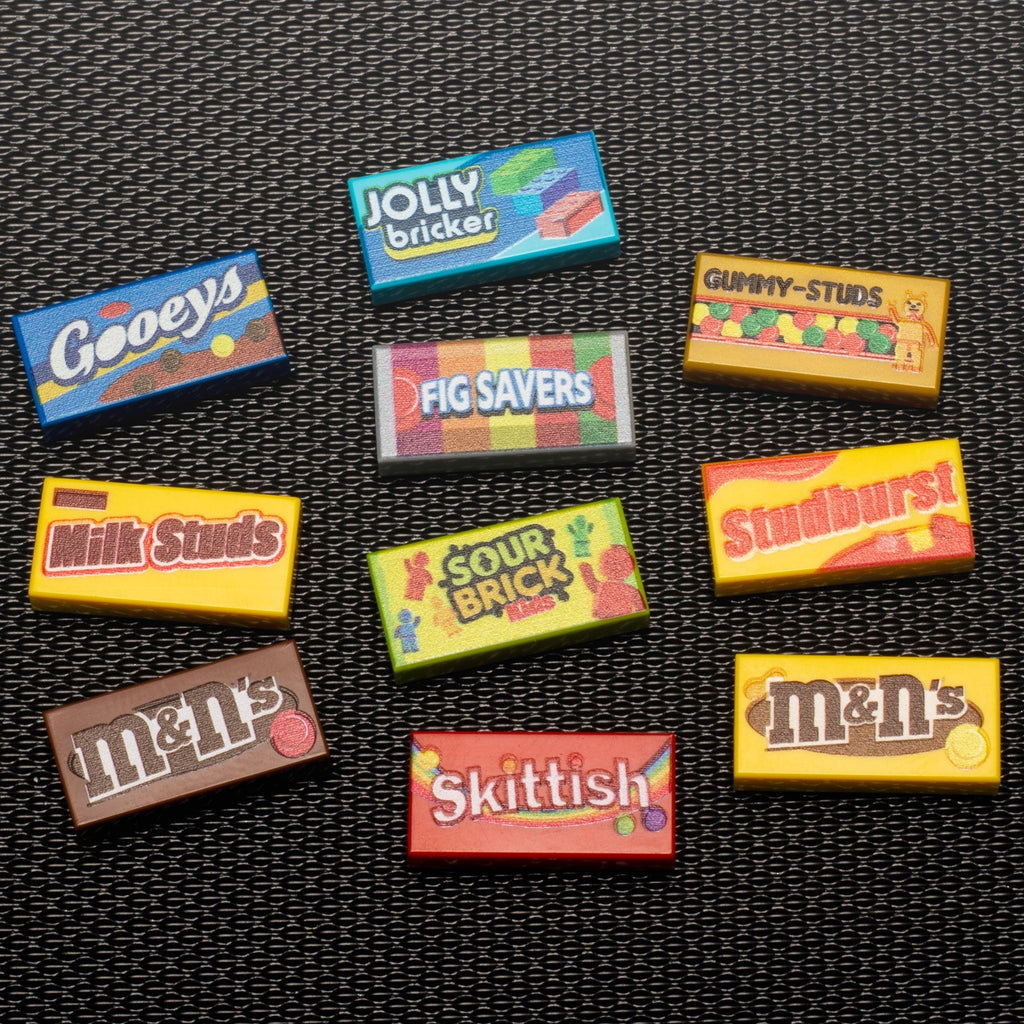 Close-up of colorful custom printed LEGO tiles arranged on a textured surface, featuring candy-inspired designs from the Candy Pack (Series 3) made from LEGO parts - B3 Customs by B3 Customs.